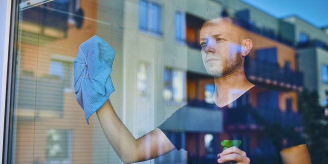 Man cleaning window at home