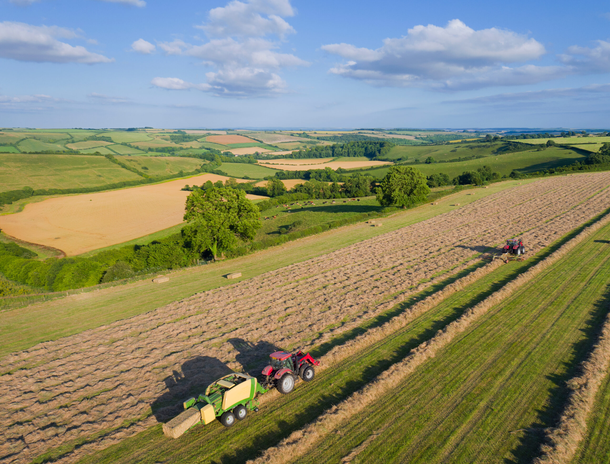 UK farming industry with agricultural fields and modern farm machinery in England