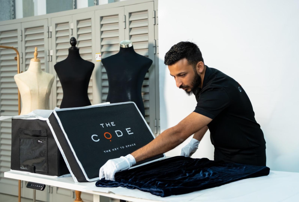 The Code employee carefully preparing clothing for storage
