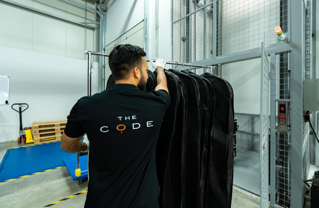The Code employee organising garment bags inside a managed storage facility